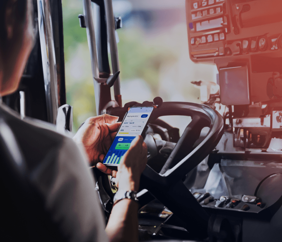 Person using GoBuid app on a smartphone while operating construction machinery